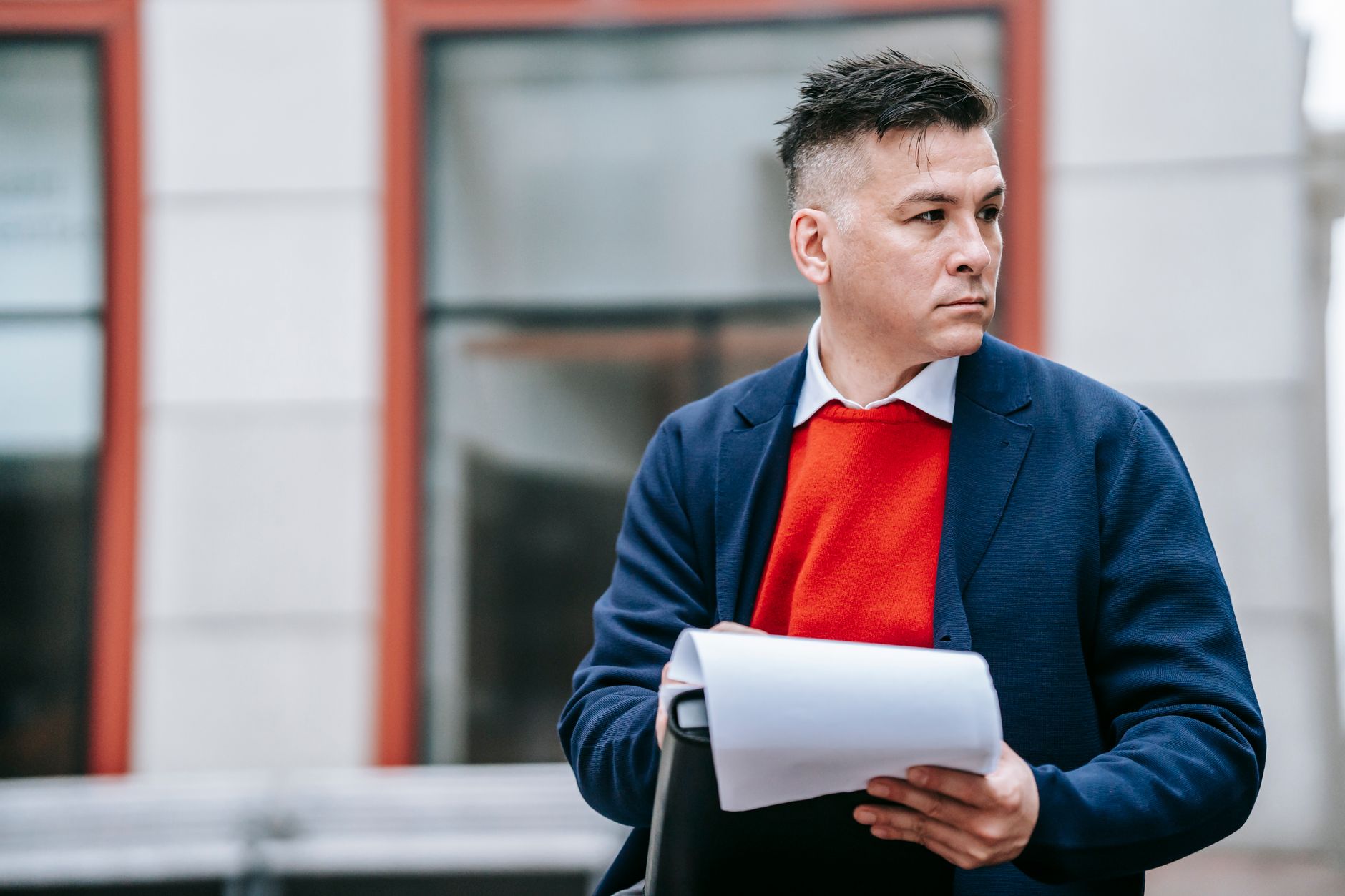 A serious man holding papers, dressed professionally in an urban environment. — 3 Social Media Platforms That Offer Paid Ads