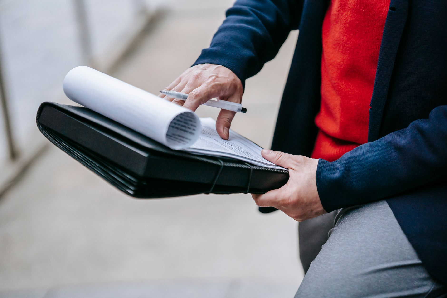 Close-up of a professional person reviewing documents outdoors. Engaged in work with focus on writing materials. — 4 Tips for