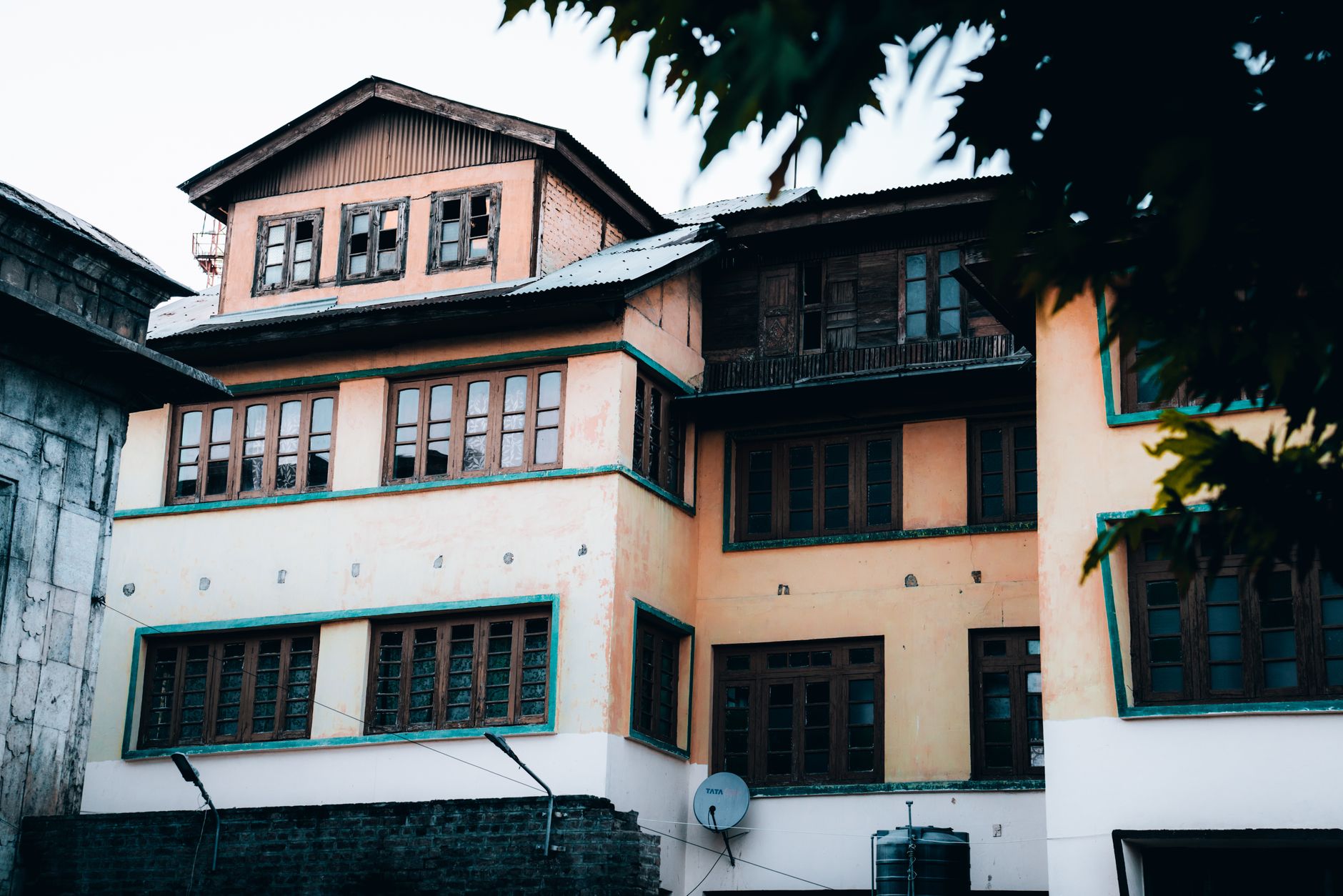 Three-story traditional house with wooden windows and pastel facade, surrounded by greenery. — 4 Ways To Upgrade Your Commerc