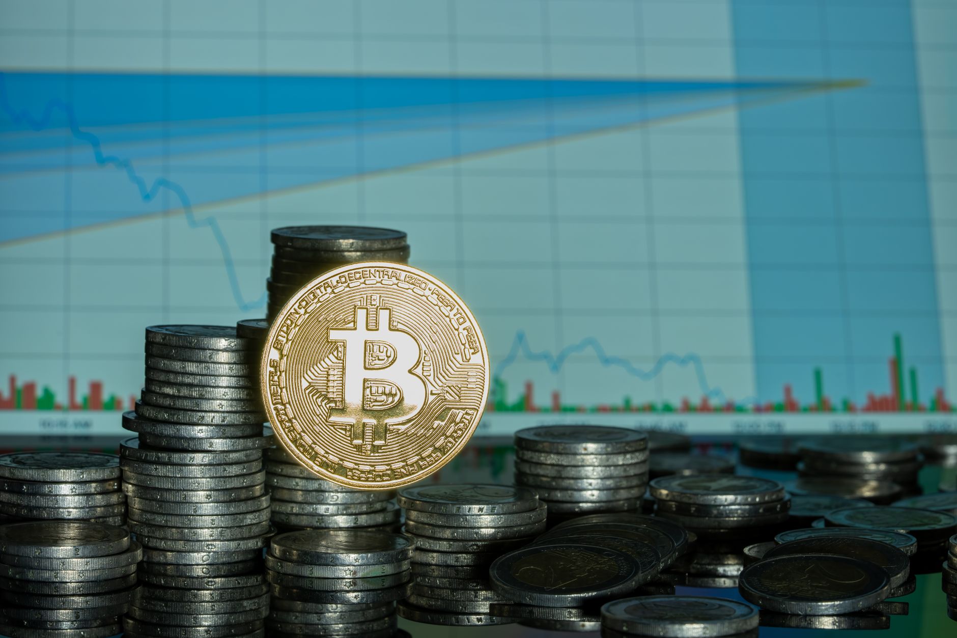 Stack of coins with Bitcoin emblem against a financial market graph, highlighting economic trends. — 5 Solid Wealth Creation