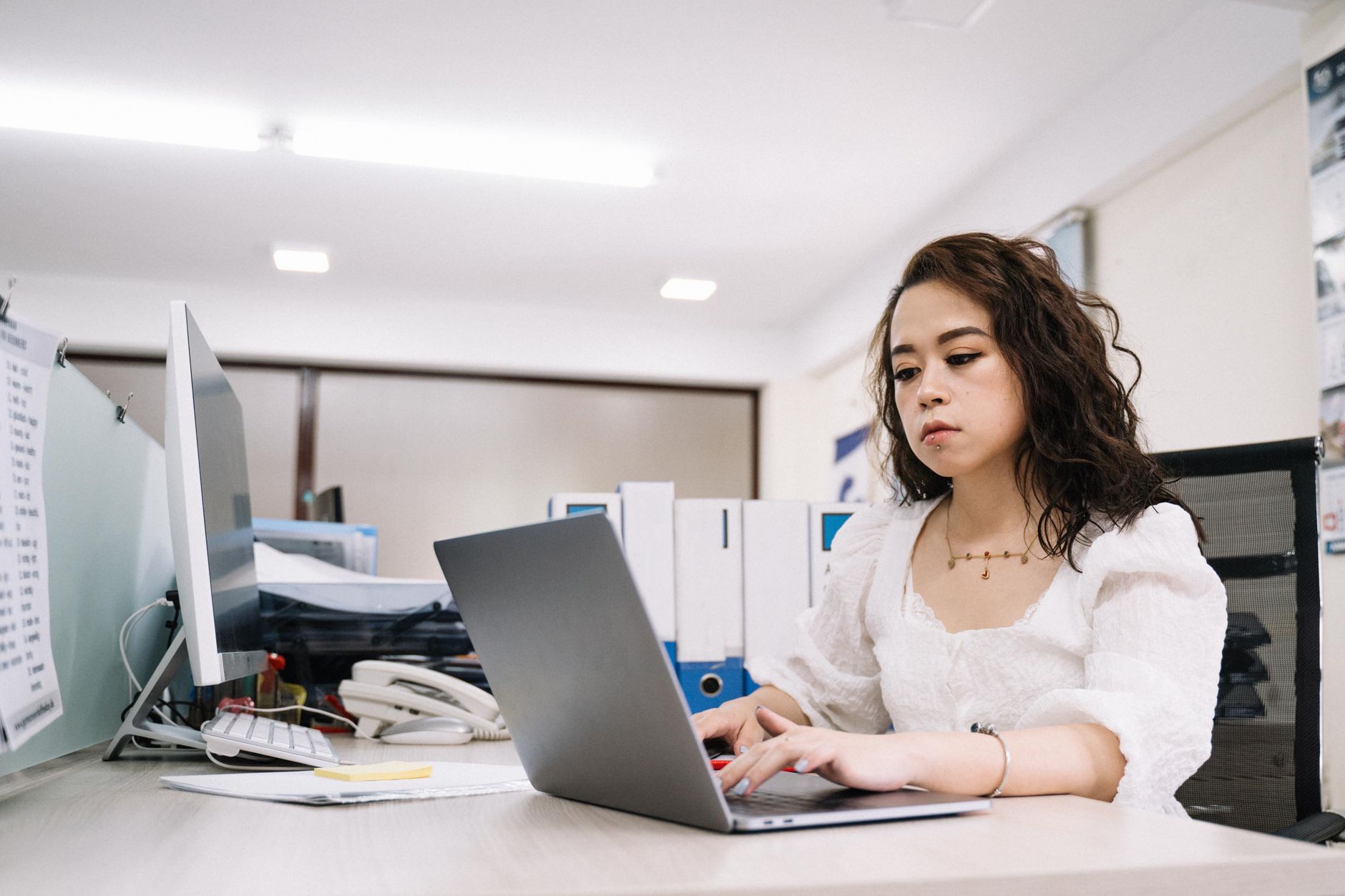 Professional woman working on a laptop in a modern office environment. — 6 Unbelievable Items That Is Really A Mastermind Ent