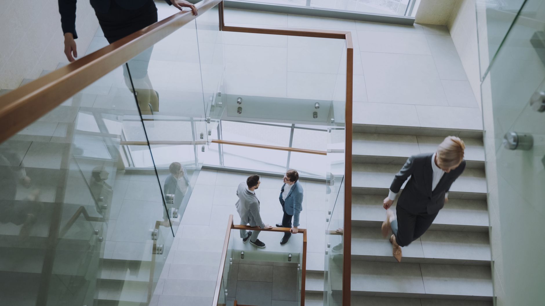 Aerial view of professionals conversing in a glass staircase in a modern office. — Advantage Of Using Double Column Machine C