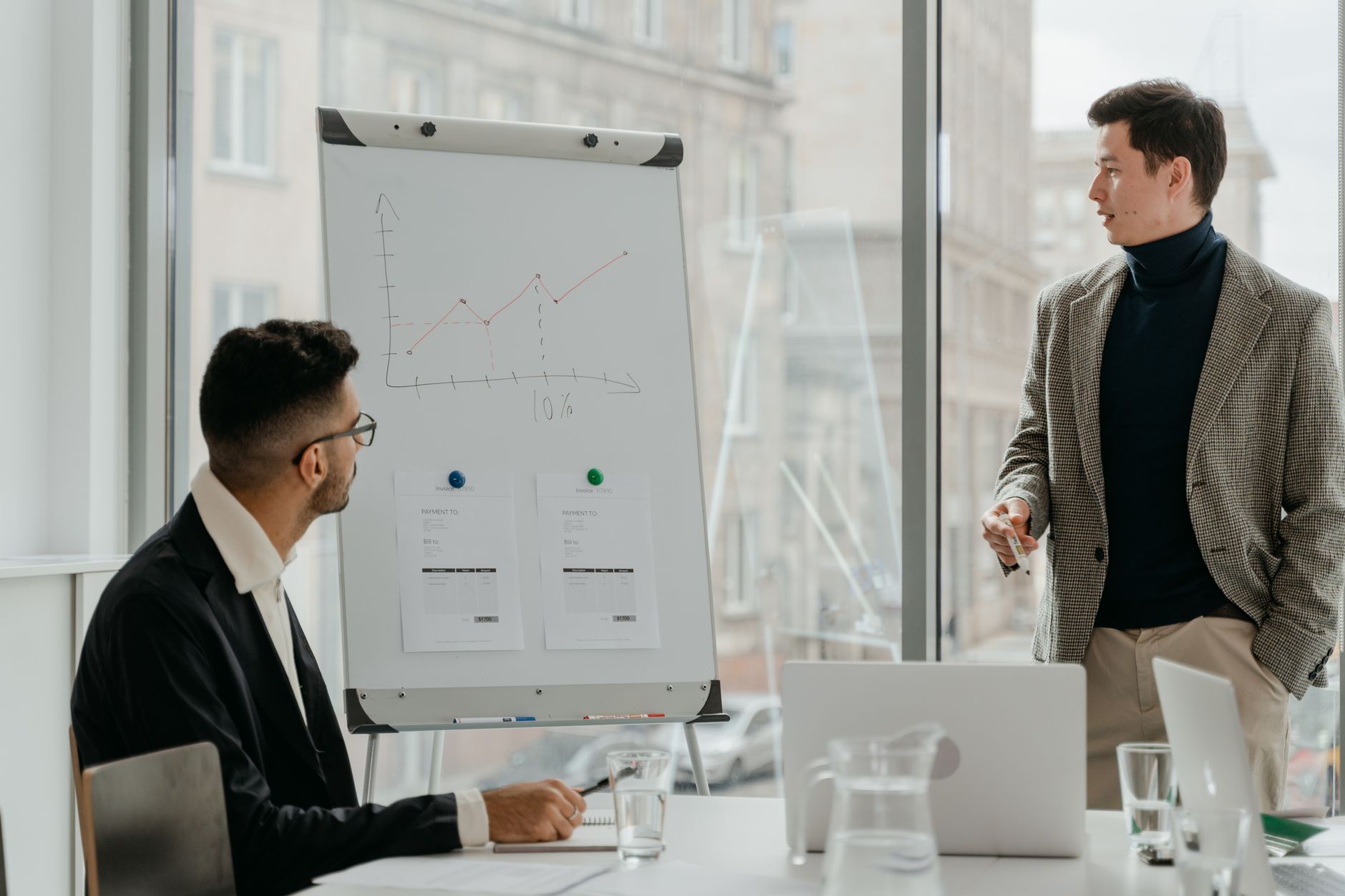 Professionals discussing a business chart in a modern office. — Benefits of Banner Ads