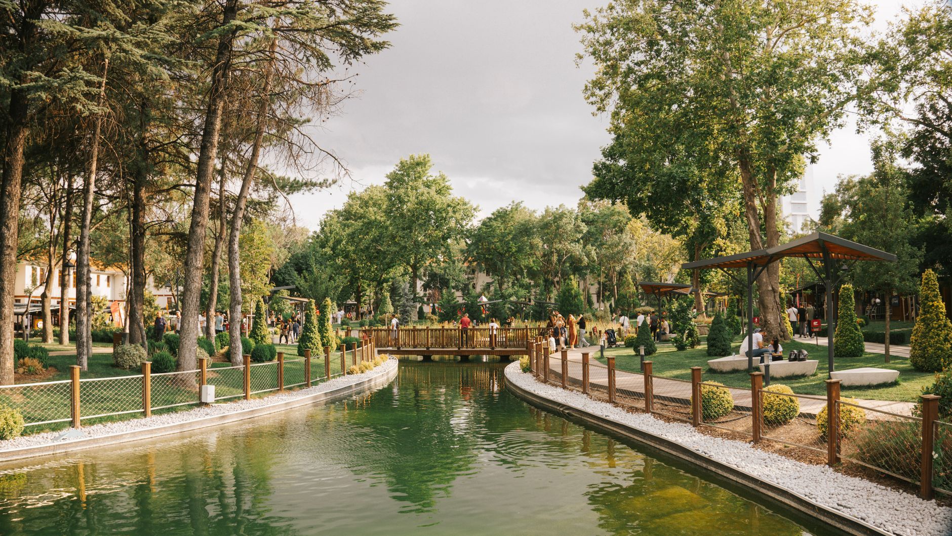 Peaceful park scene featuring a serene pond, a wooden bridge, and lush greenery. — Business card- an important segment of mar