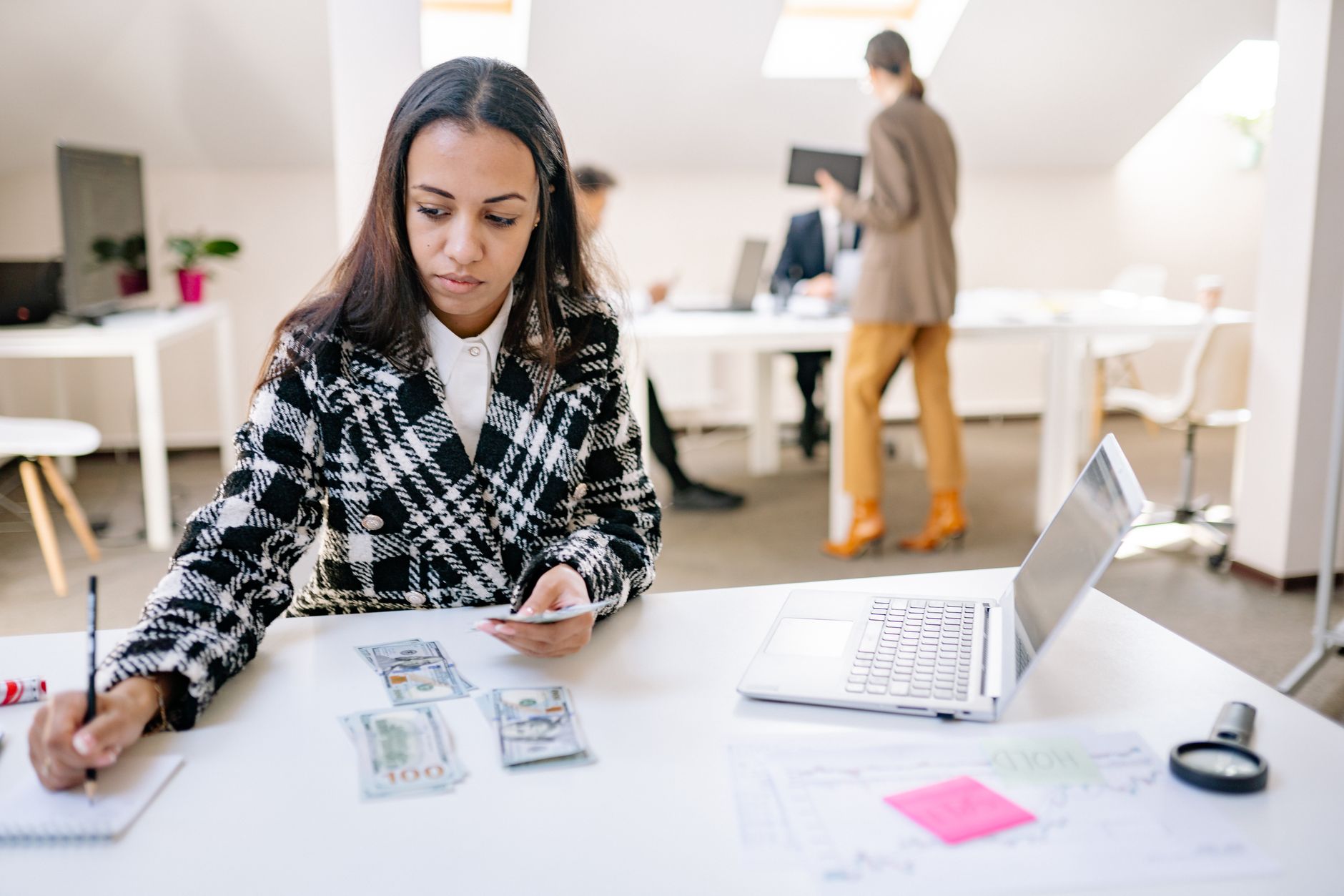 Businesswoman calculating finances with cash and a laptop in a modern office. — Create bitcoin cryptocurrency wallet with car