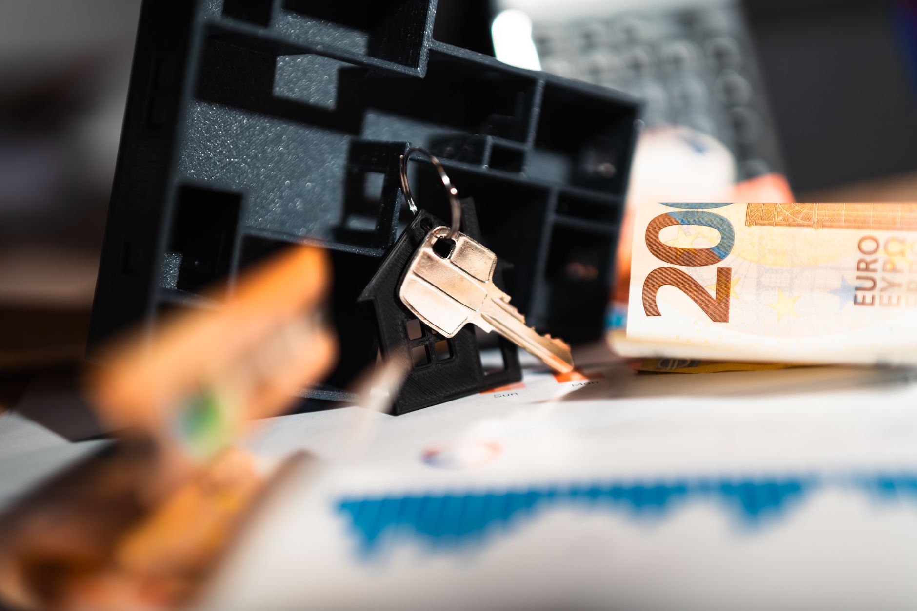Keys with a house model, Euro bills, and charts suggesting real estate and financial themes. — Essential things to know more