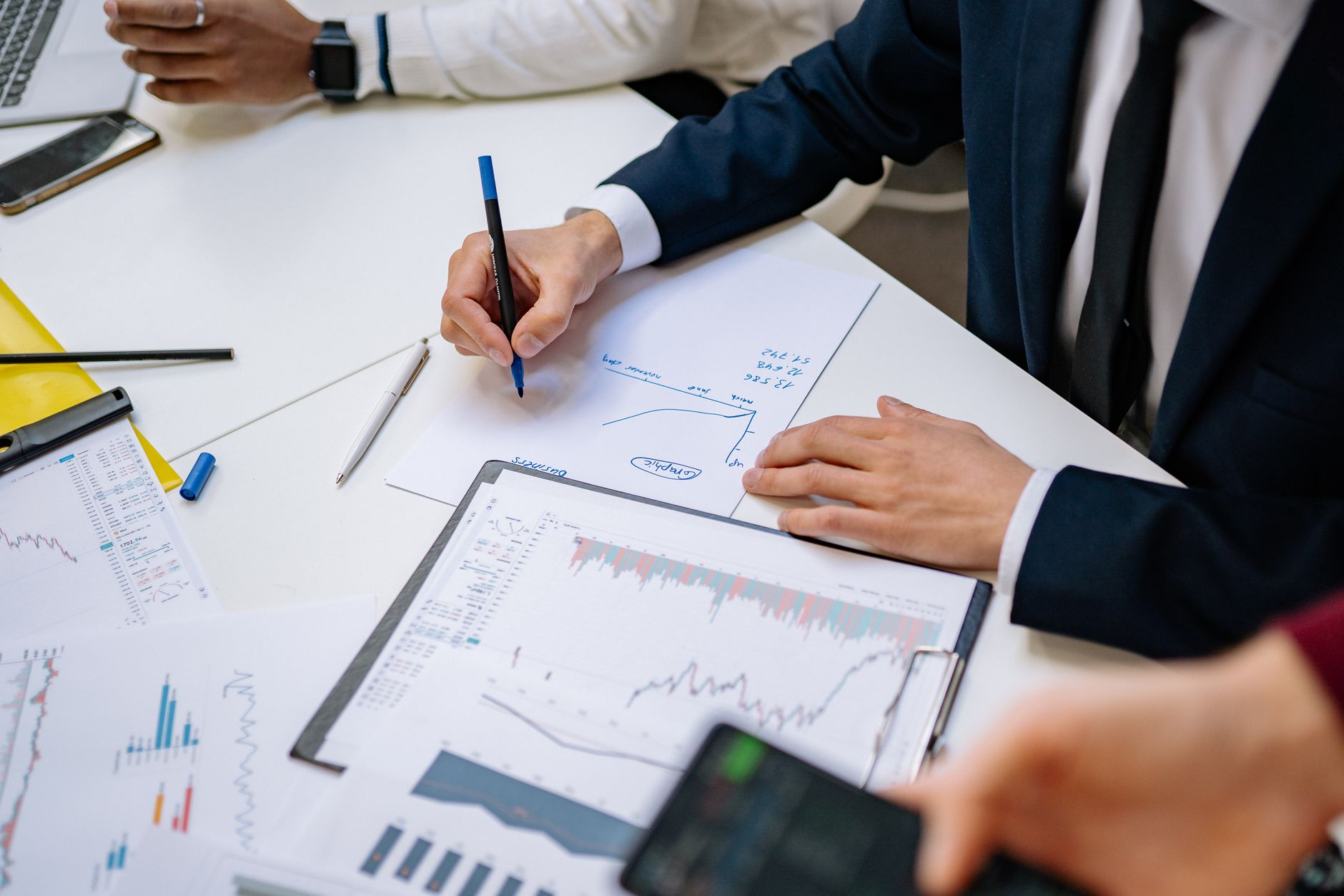 Professionals analyzing financial charts in a corporate setting. — Fundamentals to consider by the banking sector in adopting