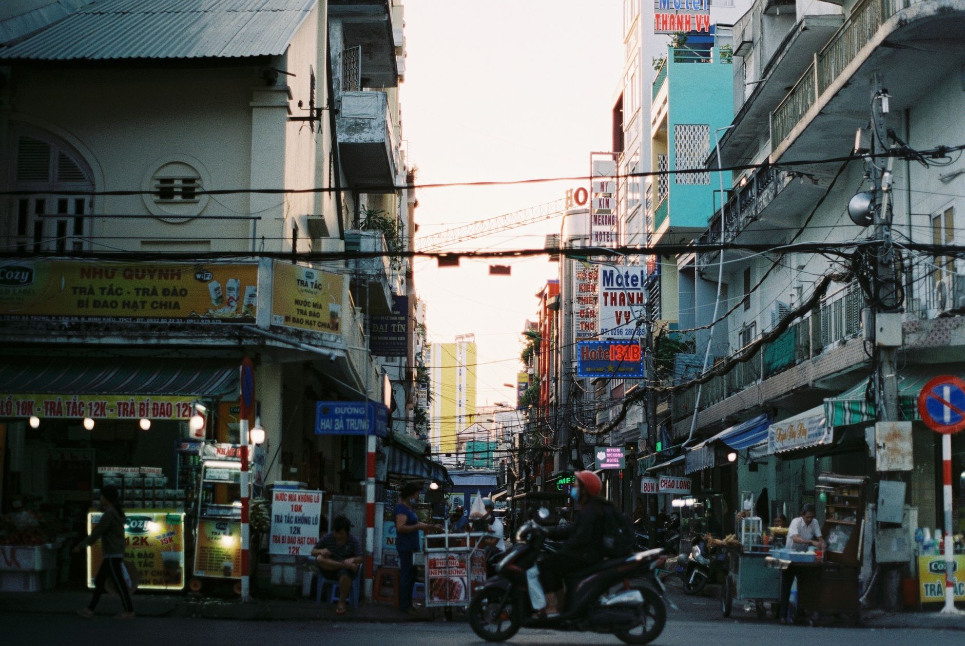 Colorful busy street scene in Cần Thơ, Vietnam with vibrant signs and people. — Get to Know Technical Analysis and Fundamenta