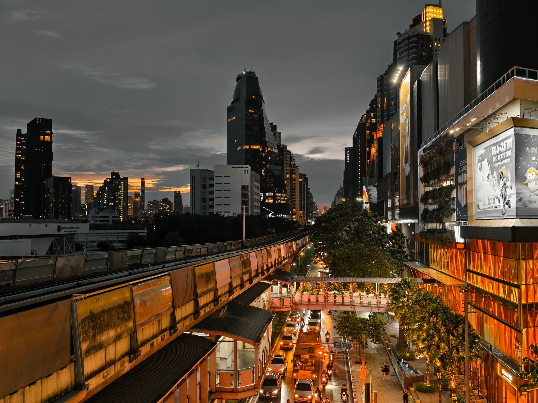 Cityscape at twilight showing busy traffic, skyscrapers, and an elevated train line in an urban setting. — Guide to digital m