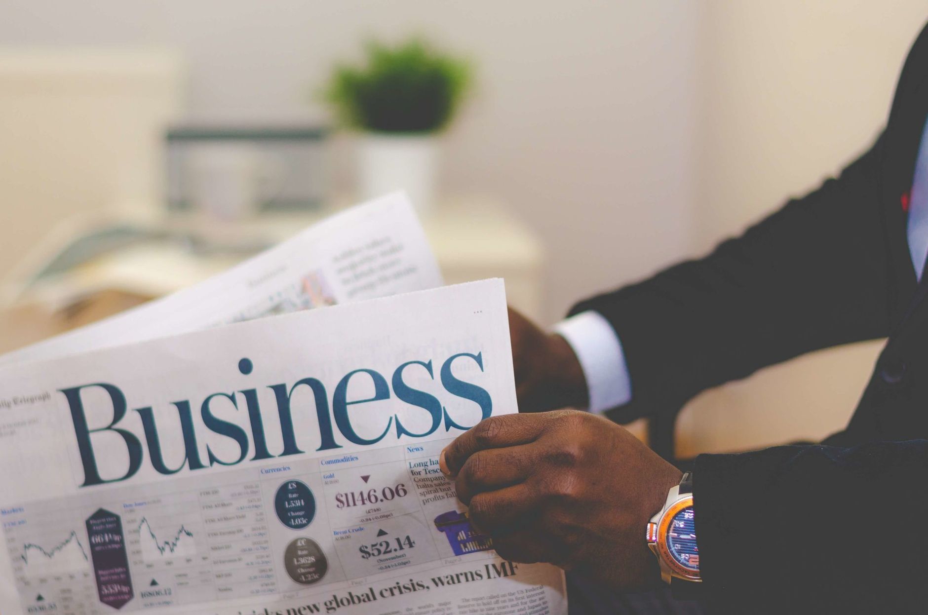 Close-up of a businessman reading a newspaper indoors, focusing on business headlines. — Highlights on The Gann Pull Back Tec