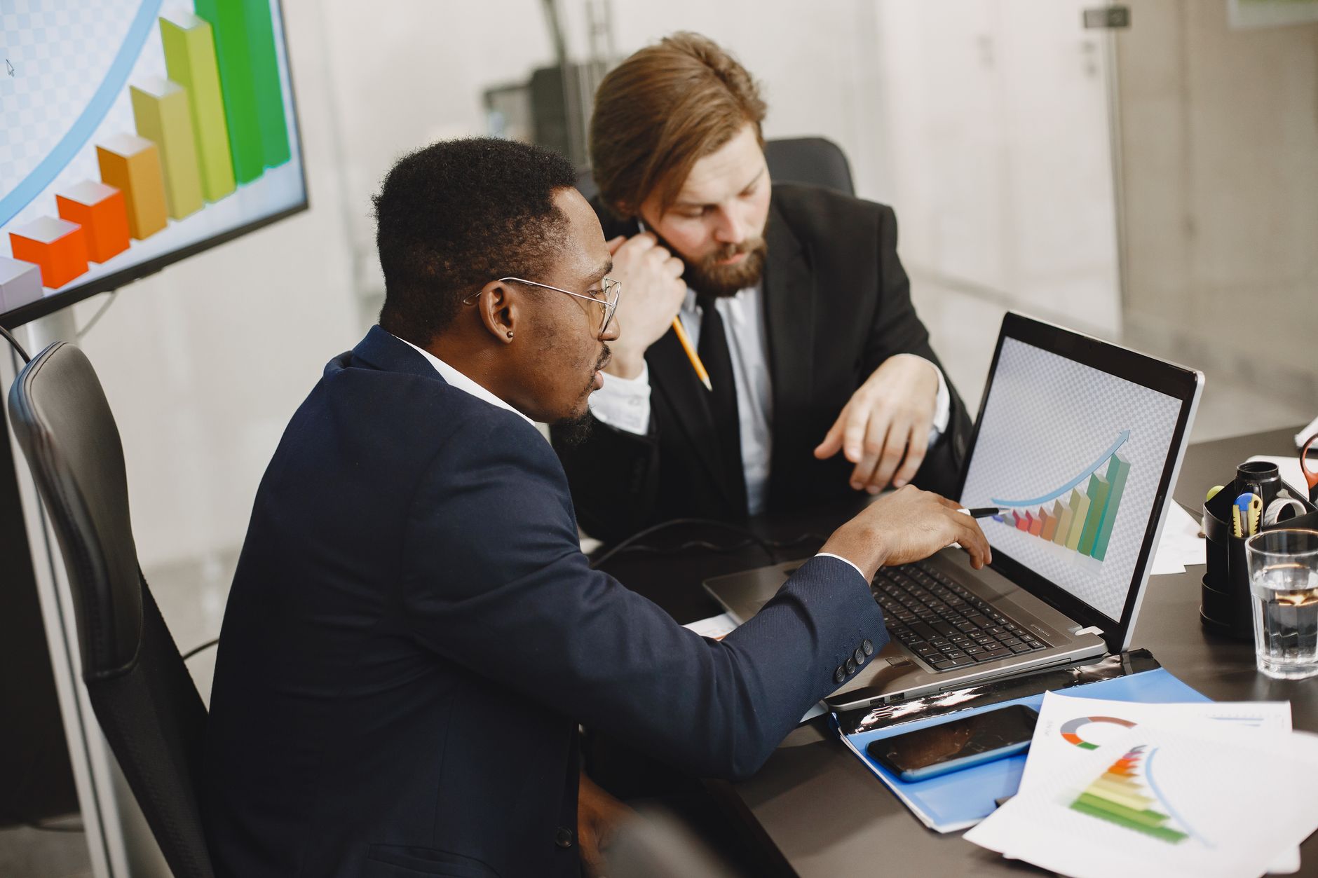 Two business professionals working on growth charts using laptop in an office setting. — How did the industrial sector evolve