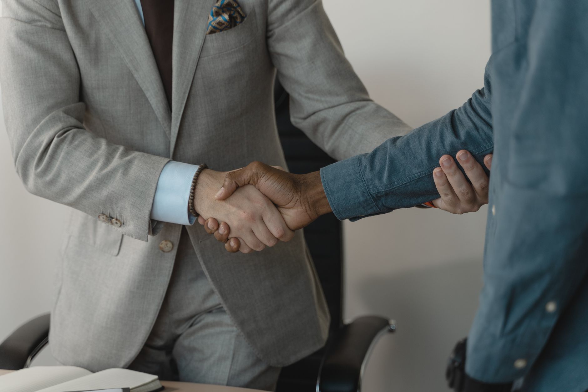 Image of a professional handshake between two businessmen in an office setting. — How to Choose the Right Backlinks Package f