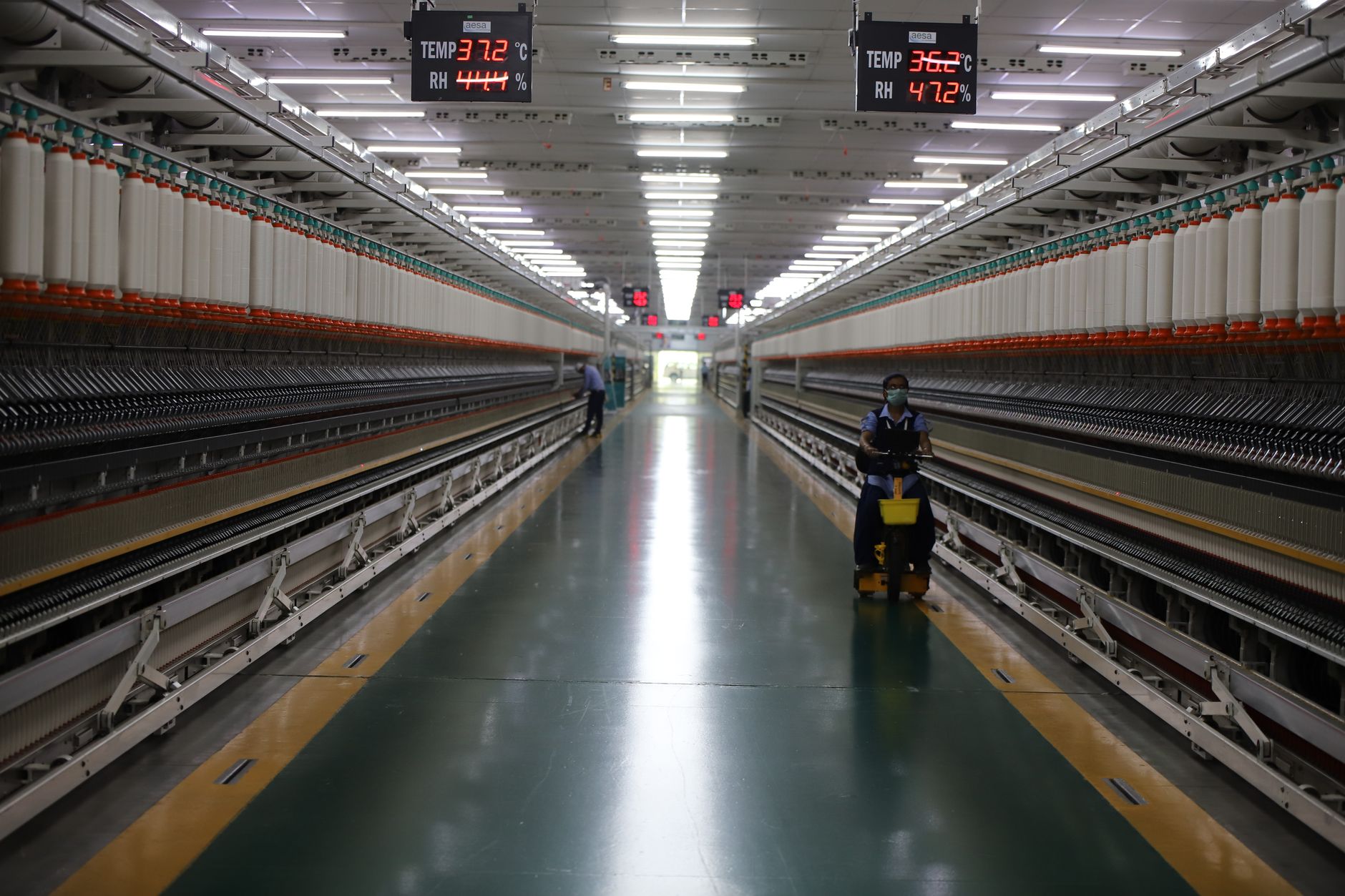 Long hallway in Indian textile factory with spinning machinery and workers. — How To Clean A Pellet Stove