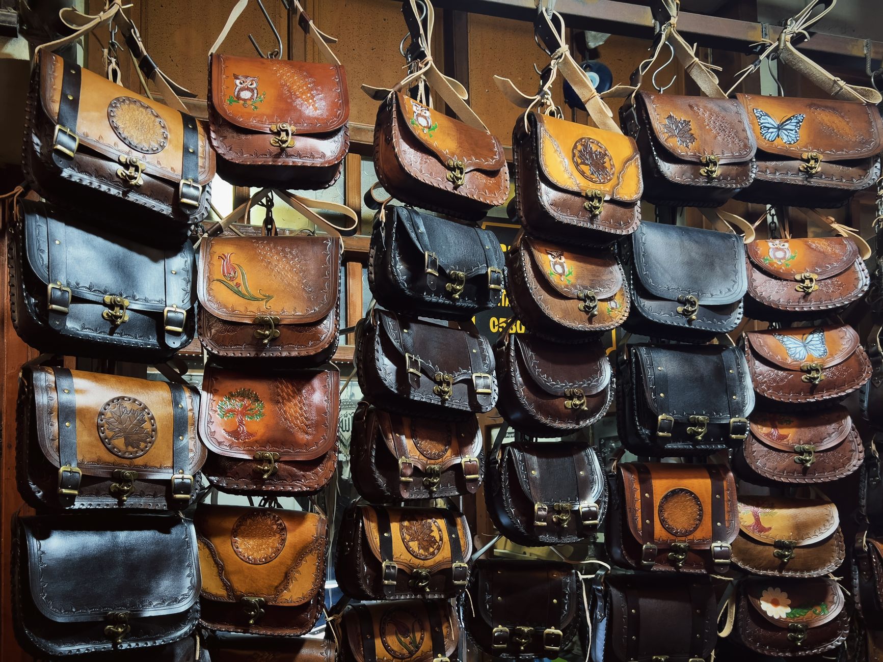 A collection of handcrafted leather bags with artistic designs on display at a shop. — How Will dental social media marketing