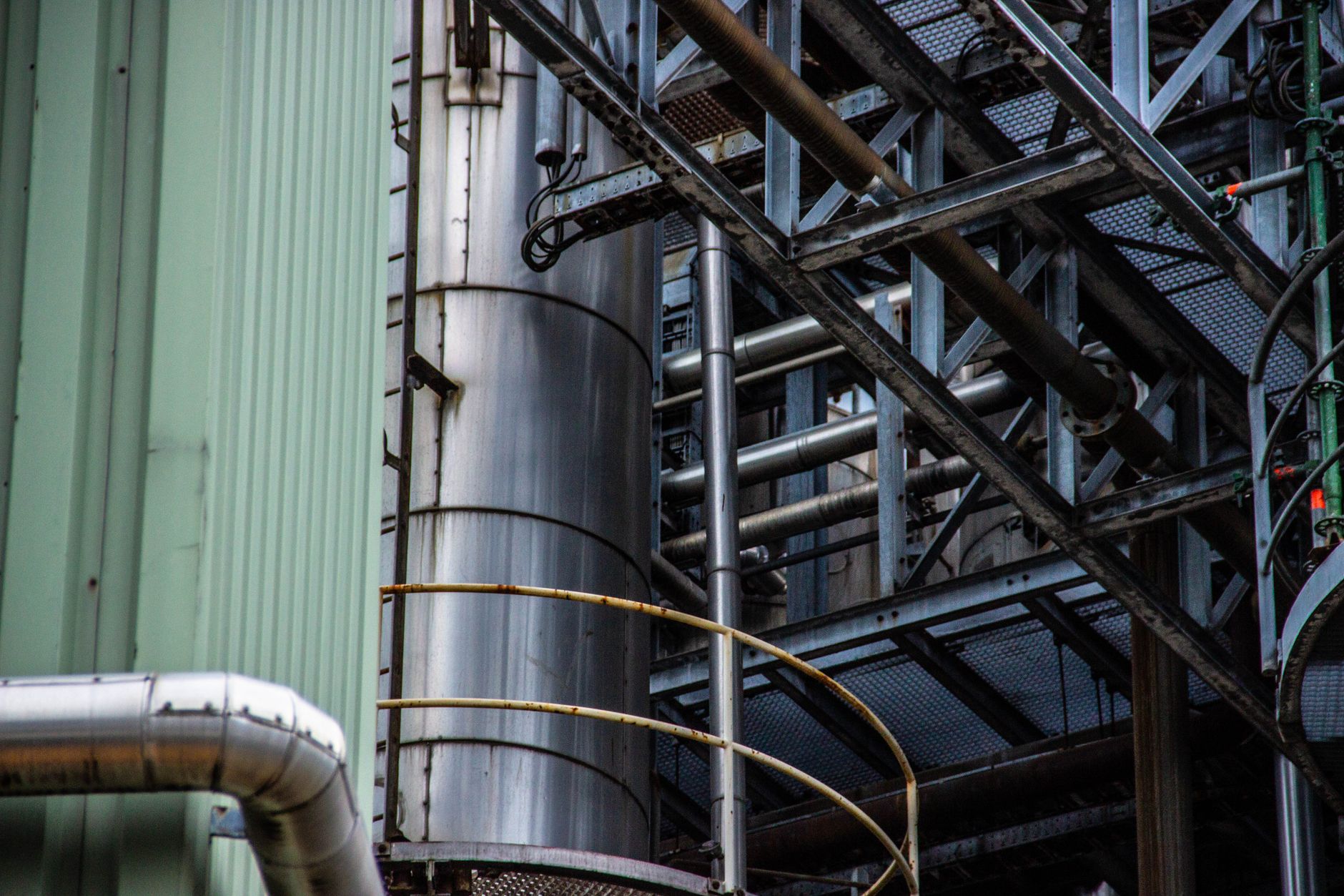 Close-up of an industrial metal structure with pipes and steel framework seen outdoors. — Industrial Coveralls and why is it