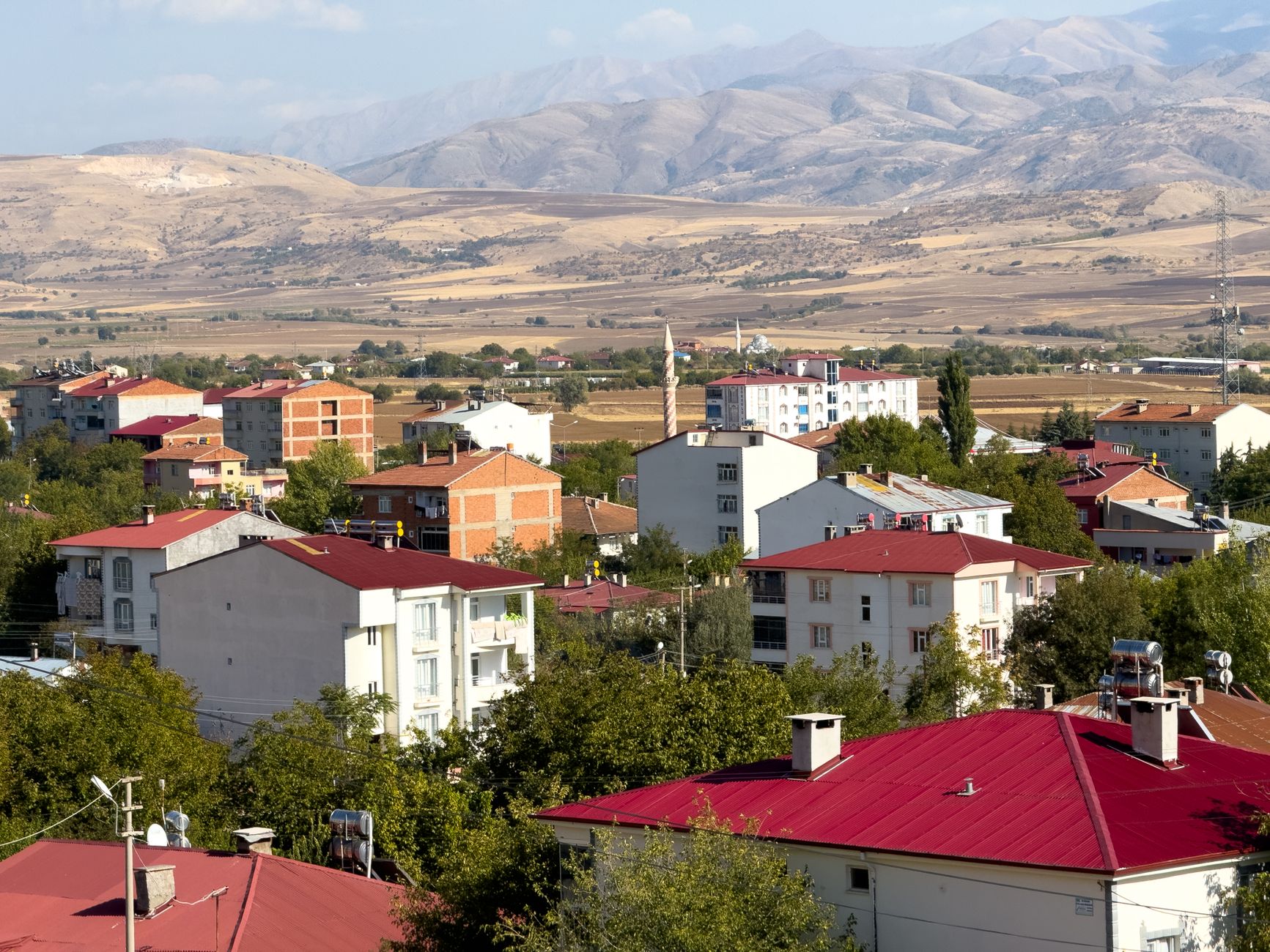 Panoramic view of Kovancılar town with red-roofed buildings against a backdrop of mountains in Elazığ, Türkiye. — Should You