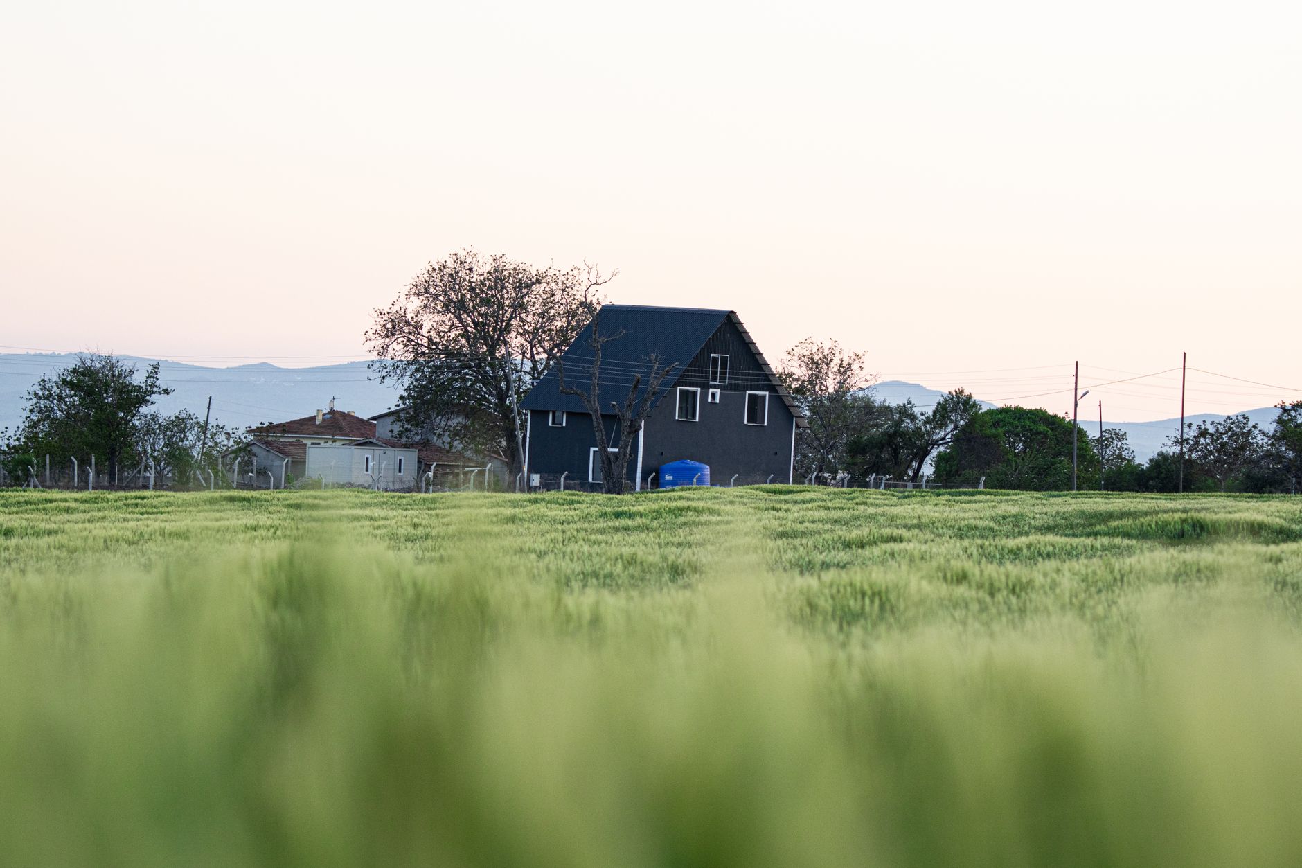 A picturesque farmhouse in a lush, green field with distant hills under a calm evening sky. — Significance Of feng shui for w