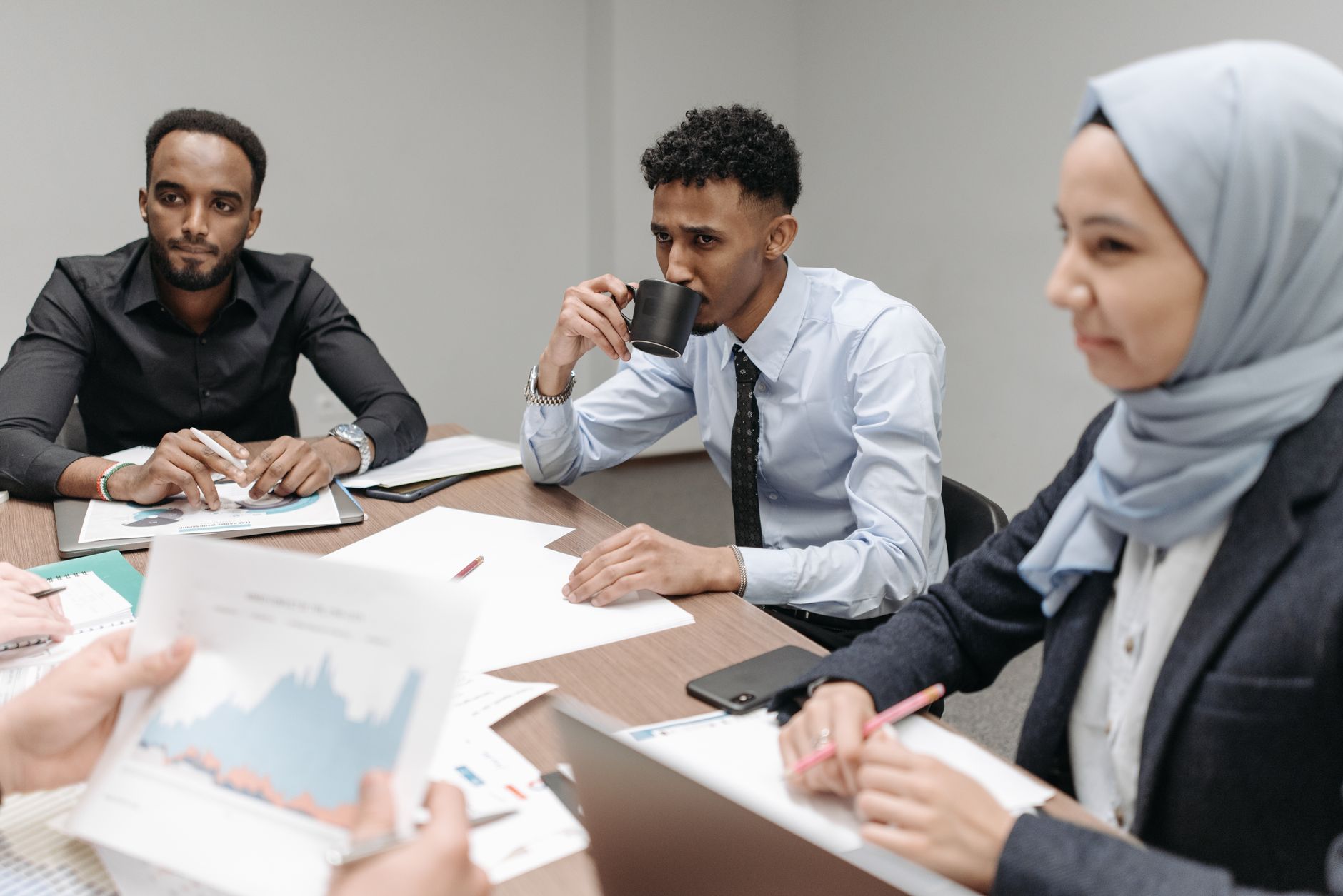 A multicultural team engaged in discussion during an office meeting, highlighting diversity and teamwork. — Tax Planning - Ho