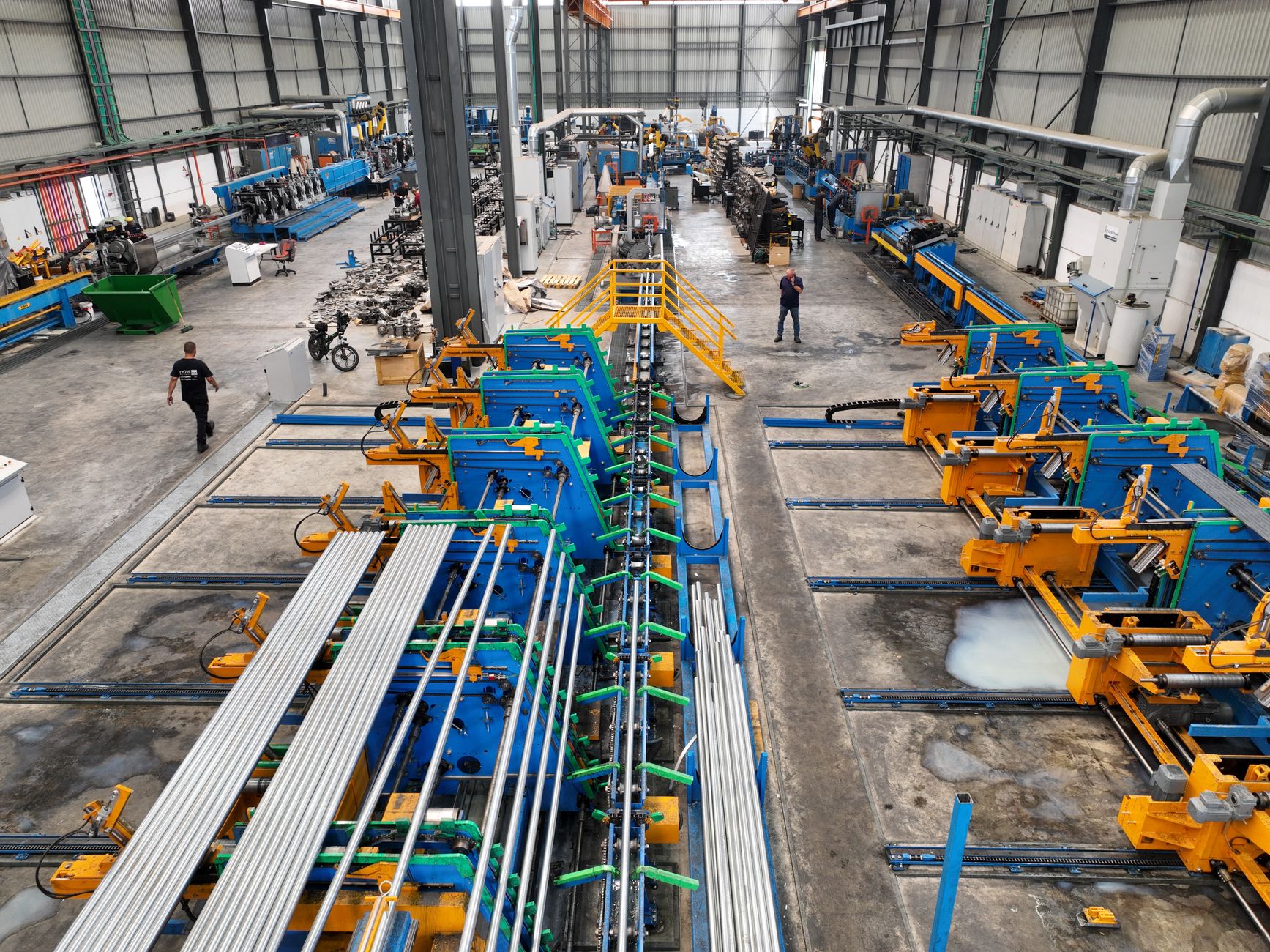 Aerial view of a large manufacturing plant interior with machinery and workers. — The Intricacy Of Shipping DG Operations