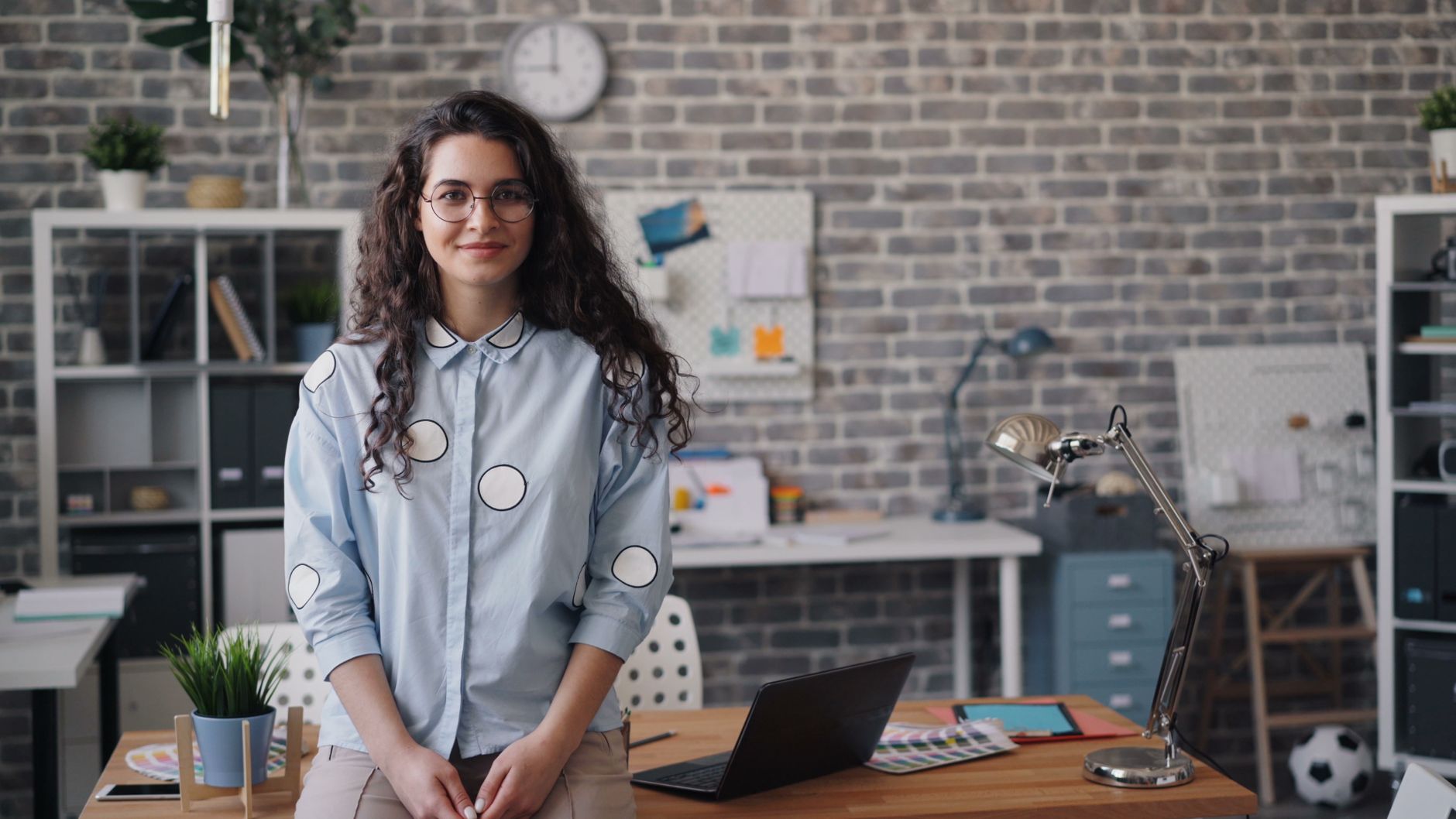 Smiling woman in a modern office space with a laptop and stylish decor. — The Options from the Entrepreneur - My Top