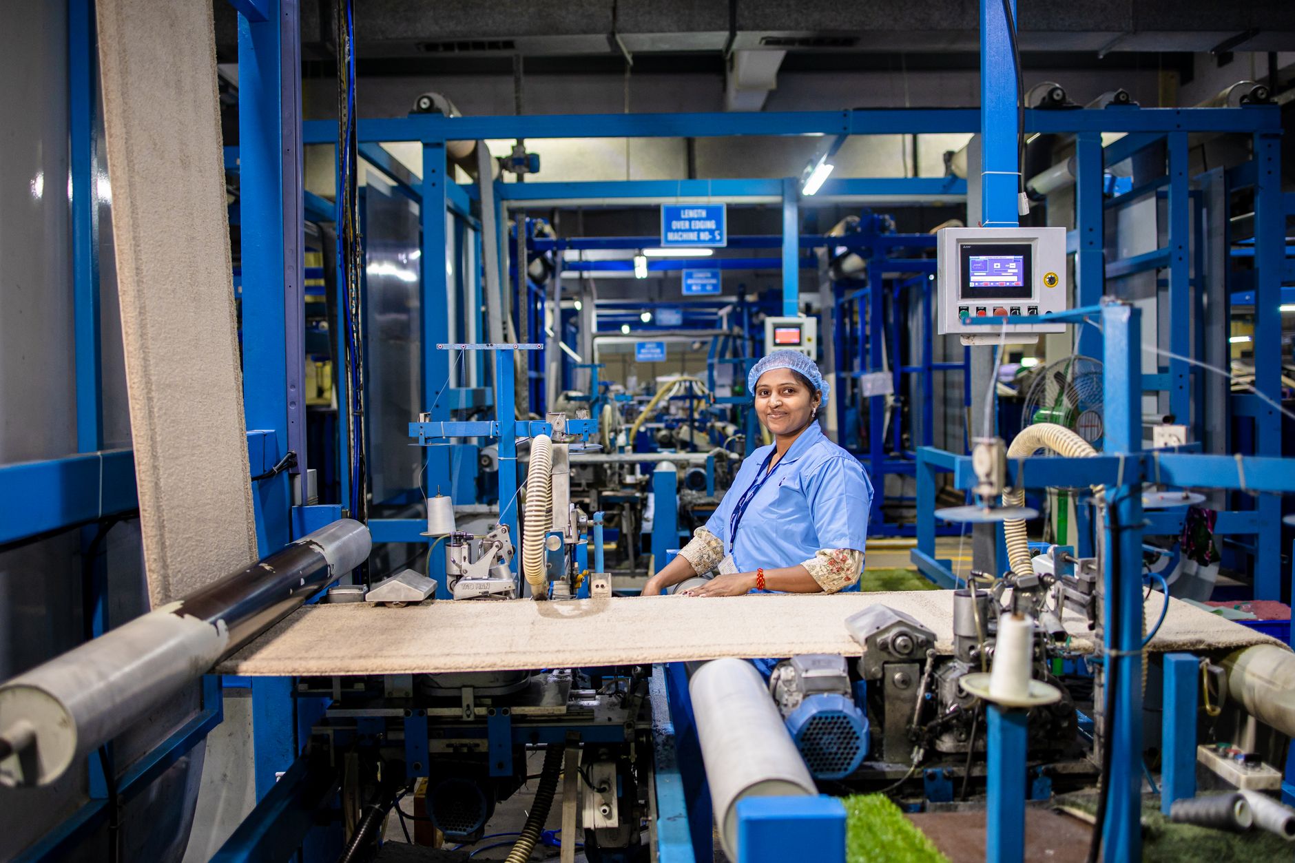 Smiling female textile worker operating machinery in a modern factory environment. — Thermal stress: materials used for wheel
