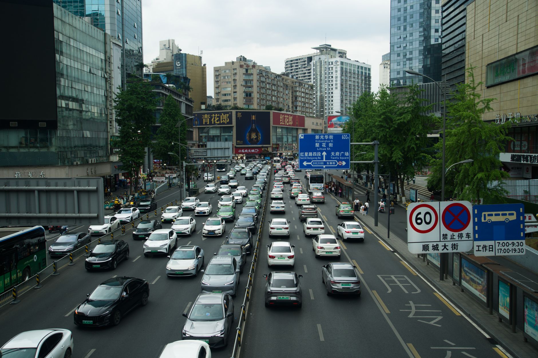 Heavy traffic on a busy Shanghai street lined with skyscrapers and billboards during the day. — Tips on Forex Trading