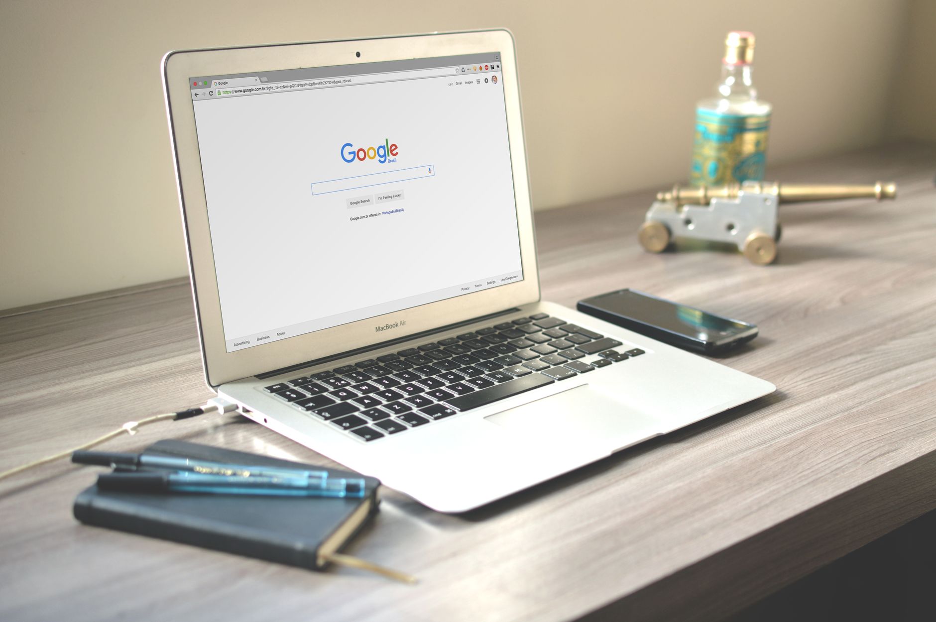 A neat workspace featuring a laptop displaying Google search, a smartphone, and a notebook on a wooden desk. — Top 4 Benefits
