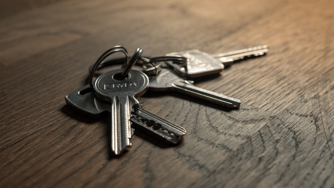 A close-up of a set of metal keys resting on a wooden surface.