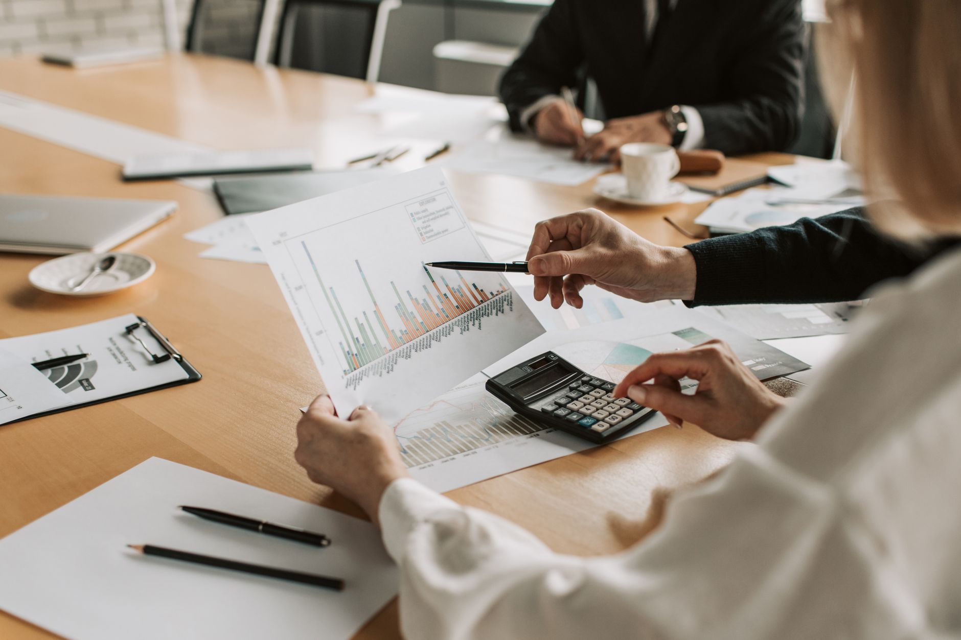 Professionals reviewing financial graphs and charts during a meeting. — What are the benefits of having MS office certificati