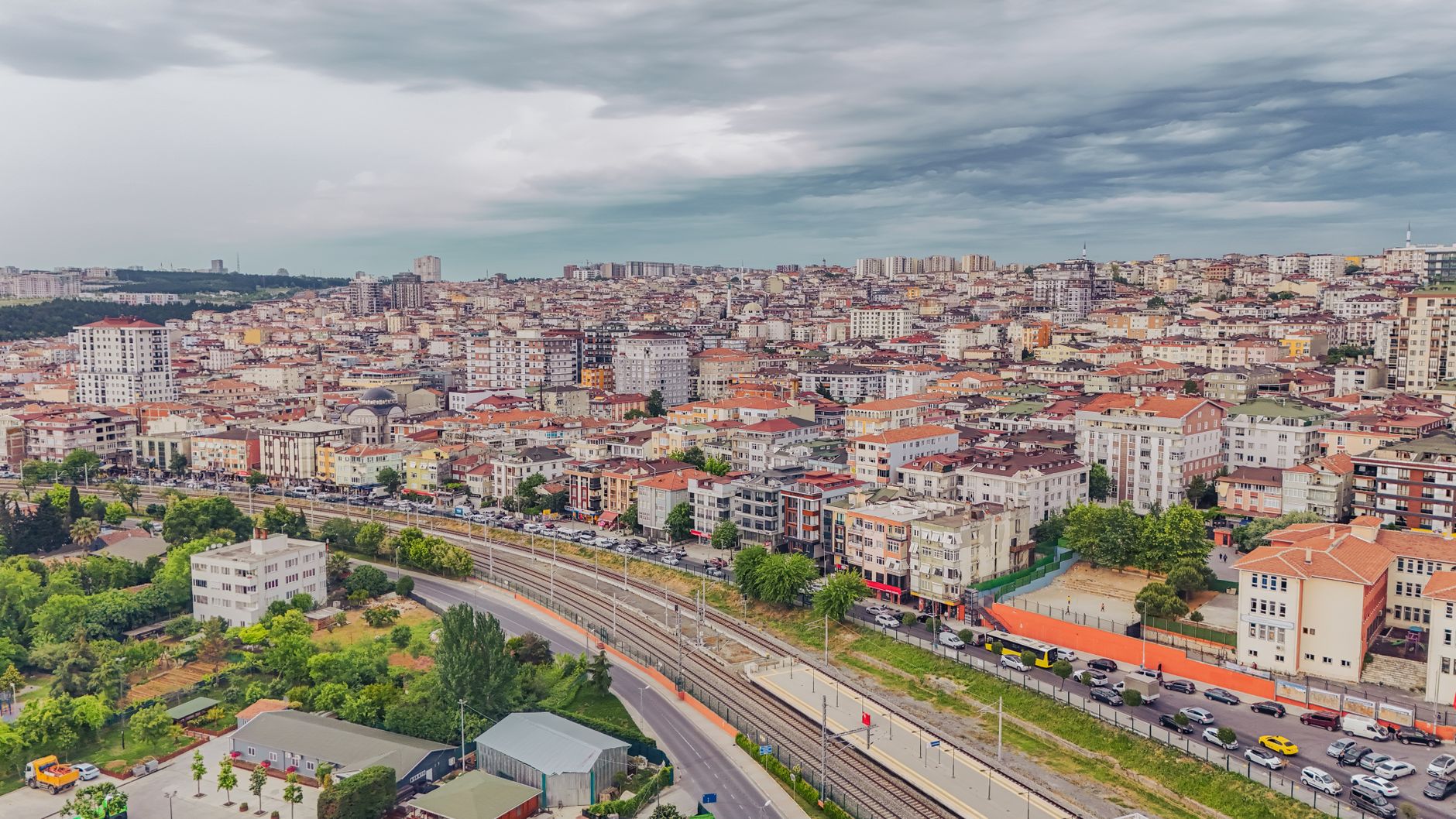 Aerial view of dense urban architecture with roads and greenery under cloudy skies. — What are the different modes of haulage