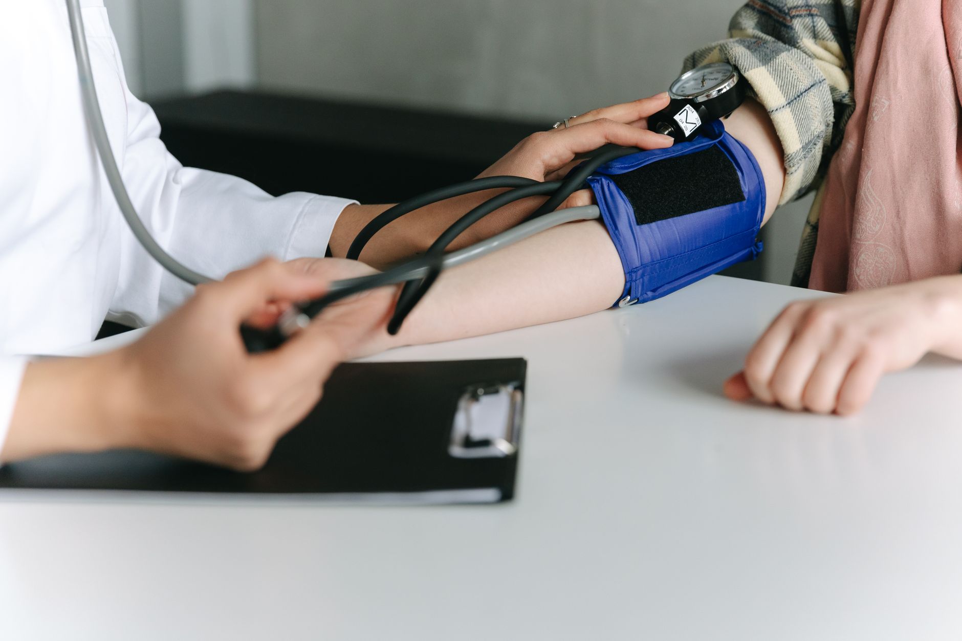 A healthcare worker uses a sphygmomanometer to check a patient's blood pressure in a medical office. — What Are The Medicare