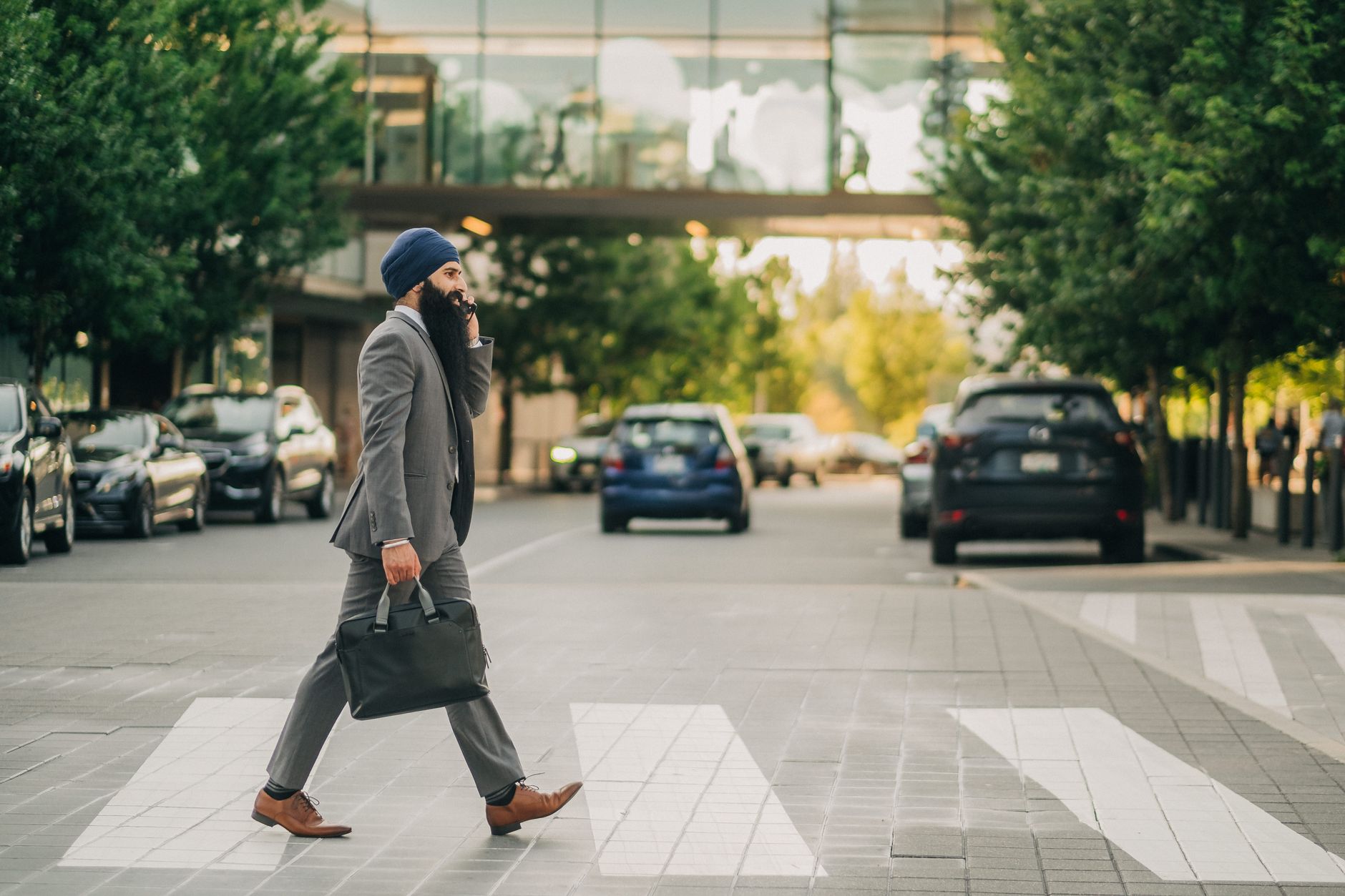 Sikh businessman with a turban crossing a city street on a zebra crossing, carrying a briefcase. — What is forex trading, and