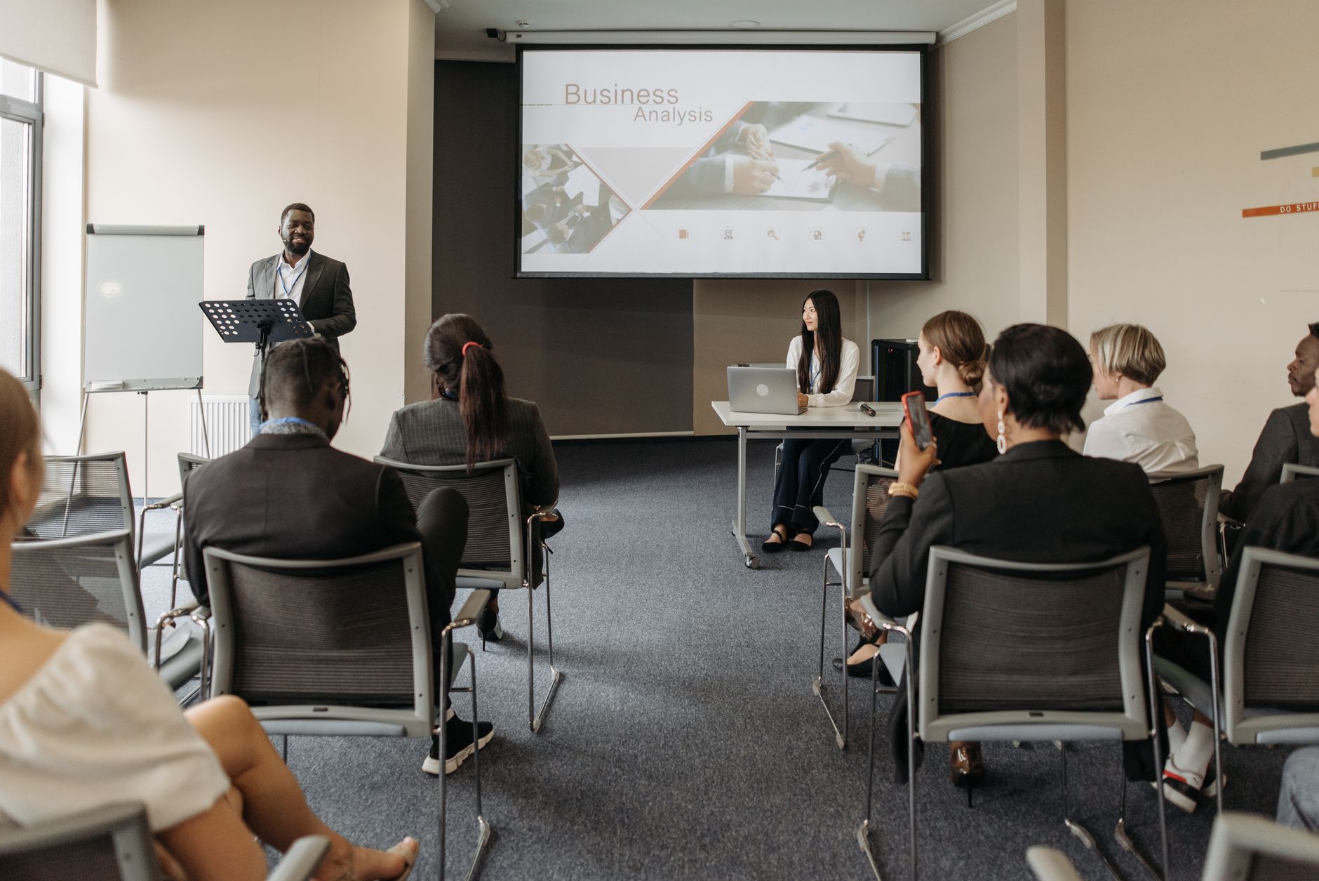 A diverse group of adults attending a presentation in a conference room setting. — Why are Backlinks relevant to websites?